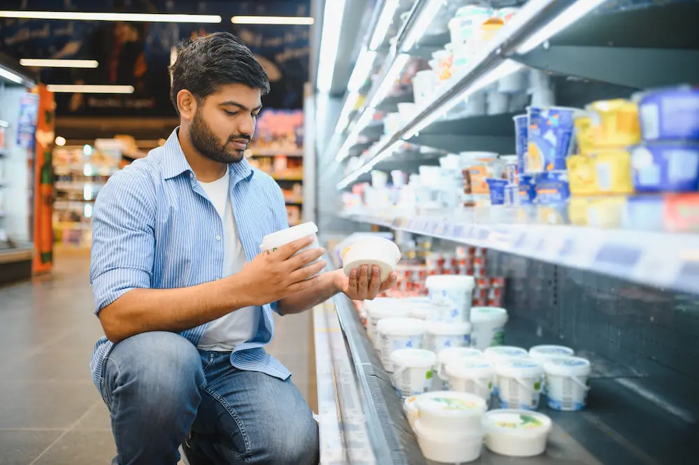 man reading nutrition label in the grocery store